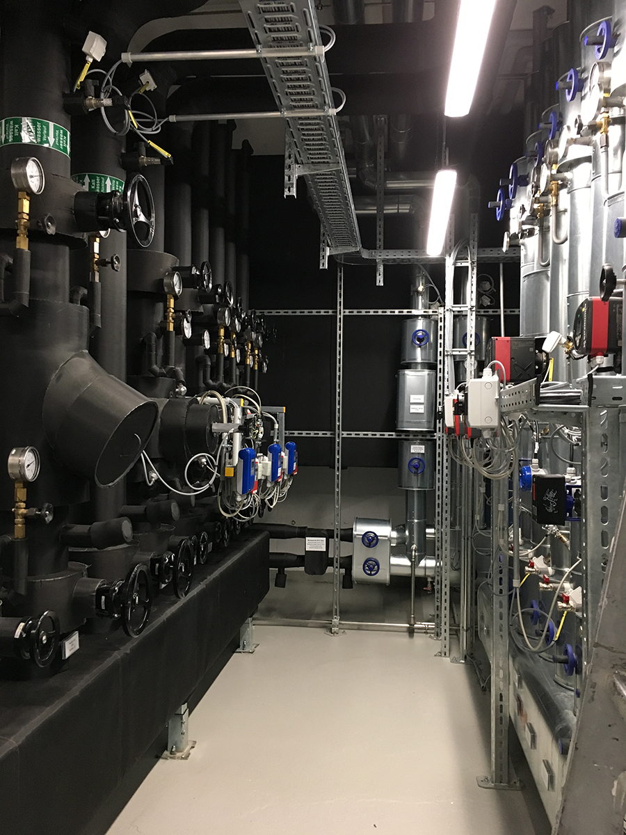 Technikzentrale mit isolierten Rohrleitungen, Manometern und motorisierten Regelventilen – Referenzprojekt der Entec Ingenieure